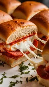 gooey pizza slider being pulled apart with melted mozzarella stretching between the rolls