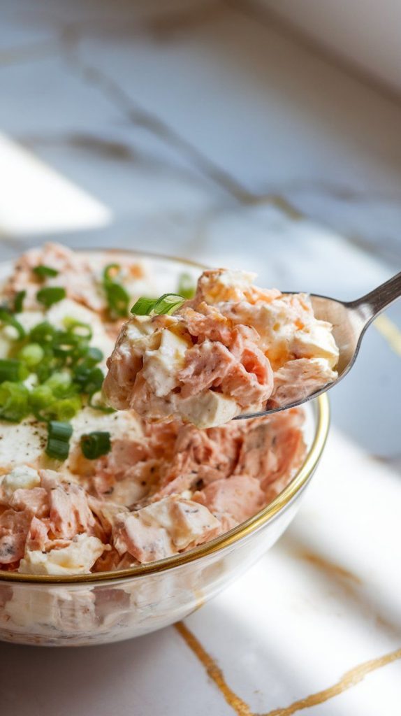 a bowl of tuna egg cottage cheese salad, garnished with finely chopped green onions.