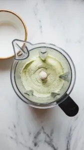 pale green cucumber-jalape&ntilde;o dip blending in the food processor, smooth texture with tiny specks of herbs