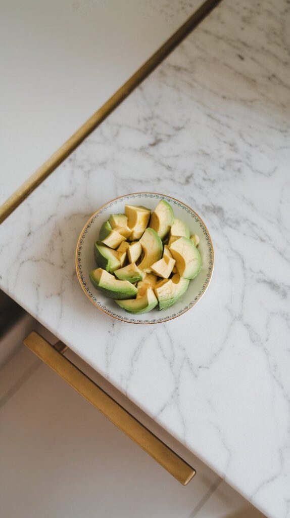 ripe avocado diced into neat cubes, creamy texture visible, sitting on a small plate with green color popping