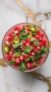 rhubarb salsa in a serving bowl, ingredients slightly softened, colors vivid and blended.