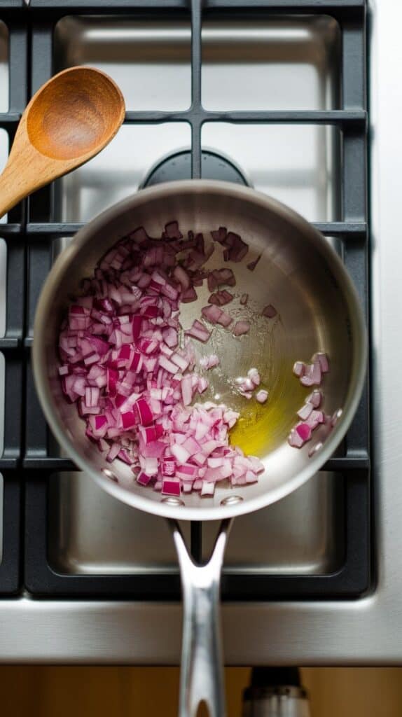 finely chopped red onion being sautéed in olive oil, just starting to soften and turn translucent, in a small saucepan