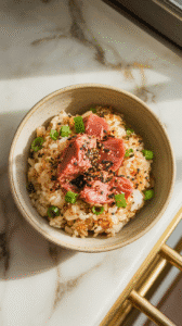 furikake tuna fried rice served in a shallow ceramic bowl, sprinkled with extra furikake and topped with a halved soft-boiled egg