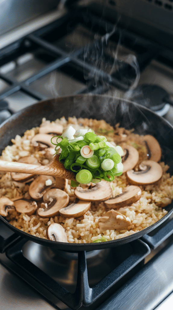 soy sauce and sesame oil coating the rice, mushrooms and garlic bits peeking through, rice grains turning golden.
