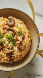 mushroom garlic fried rice served in a ceramic bowl with extra green onions and chili oil drizzle.