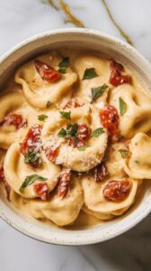 A bowl of ravioli with tomatoes and cheese.